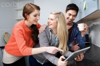 Students in kitchen using digital tablet