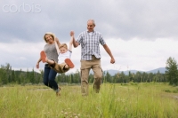 Grandparents having fun with grandson in meadow